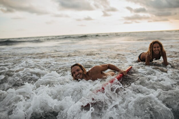 La donna e il suo ragazzo surfano nell'oceano