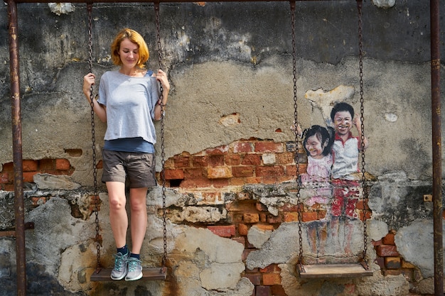 La donna è salito a uno swing con graffiti altalena accanto