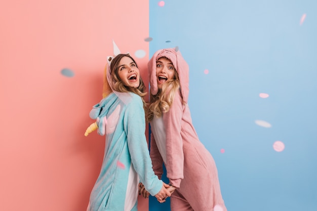 La donna emotiva indossa un kigurumi rosa che ride davanti