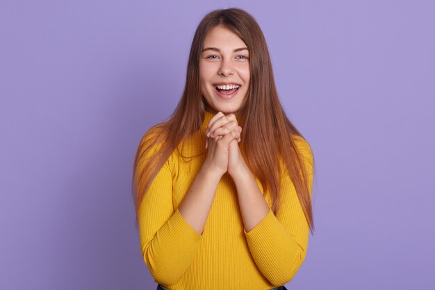 La donna emozionante in abbigliamento casuale sta ridendo insieme con le mani