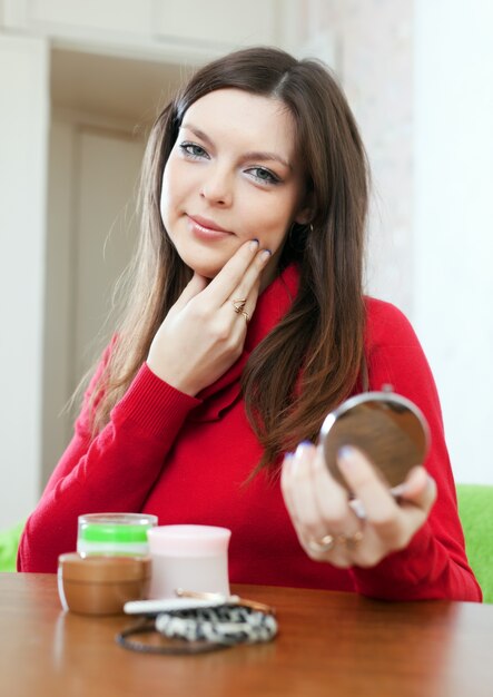 La donna guarda sul viso nello specchio