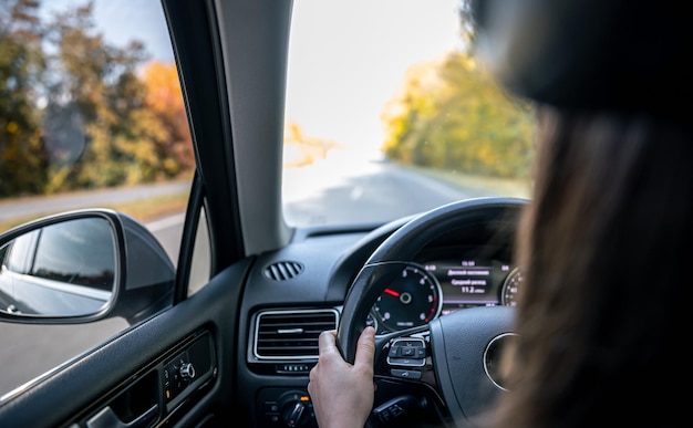 La donna guida le mani sul volante all'interno dell'auto