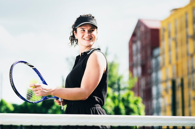 La donna in abbigliamento sportivo serve la pallina da tennis