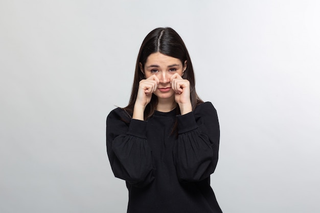 La donna in maglione nero dimostra la faccia di pianto