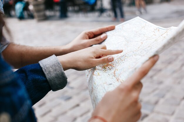 La donna in rivestimento dei jeans tiene nella sua mappa turistica delle mani