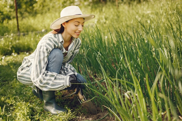 La donna in un cappello che lavora in un giardino