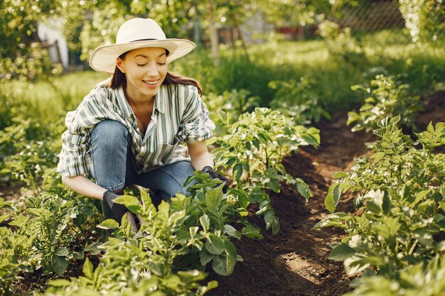 La donna in un cappello che lavora in un giardino