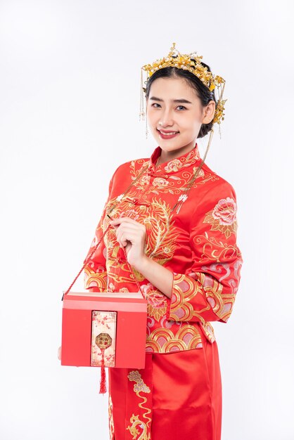 La donna indossa il sorriso del vestito cheongsam per ottenere i soldi del regalo dal capo nel capodanno cinese