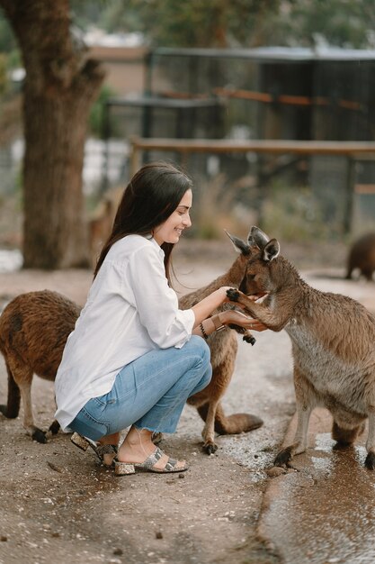 La donna nella riserva sta giocando con un canguro