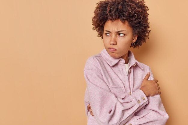 la donna non ti parla imbronciata e distoglie lo sguardo tiene le braccia conserte fa una smorfia delusa indossa una giacca isolata sul beige con copia spazio per i tuoi contenuti pubblicitari