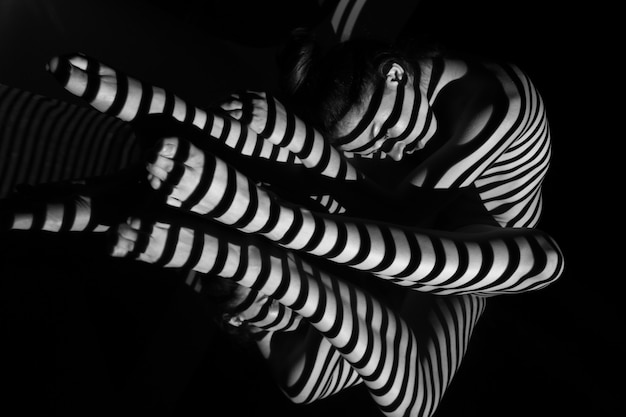 La donna nuda con strisce zebrate bianche e nere