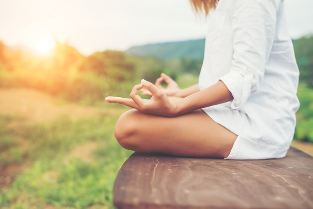 La donna passa meditazioni yoga e facendo un simbolo zen con lei ha