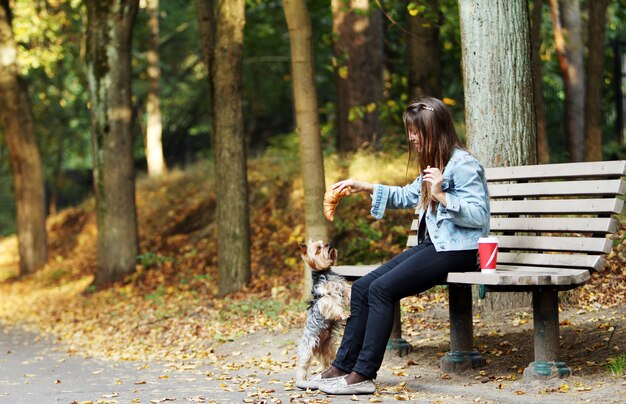 La donna pranza mentre passeggia con il suo cane