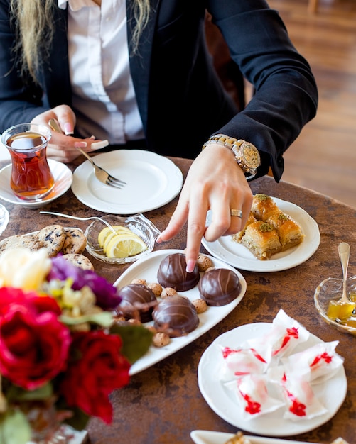 La donna prende la torta al cioccolato da mangiare con il tè