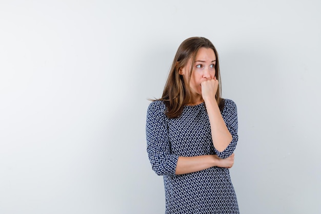 la donna preoccupata sta mettendo il pugno sulla bocca su sfondo bianco