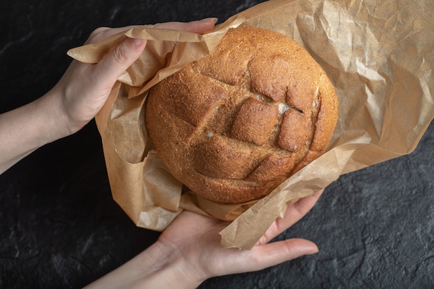 La donna scartare il pane di segale appena sfornato.