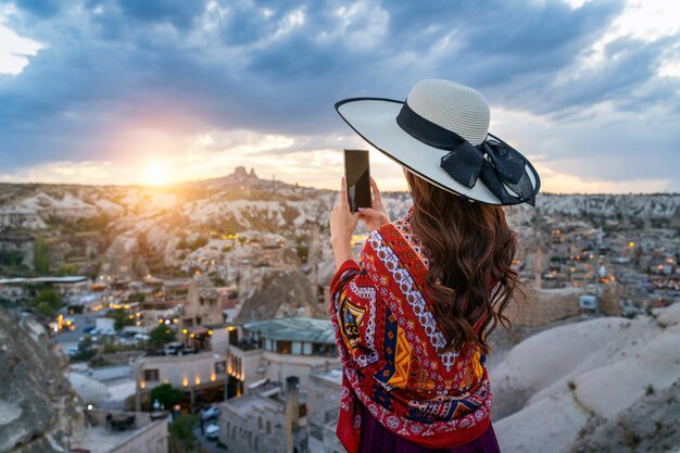 La donna scatta una foto con il suo smartphone a Goreme, Cappadocia in Turchia.