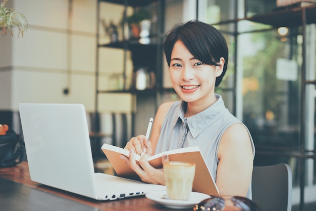 La donna scrive su un quaderno in un negozio di caffè