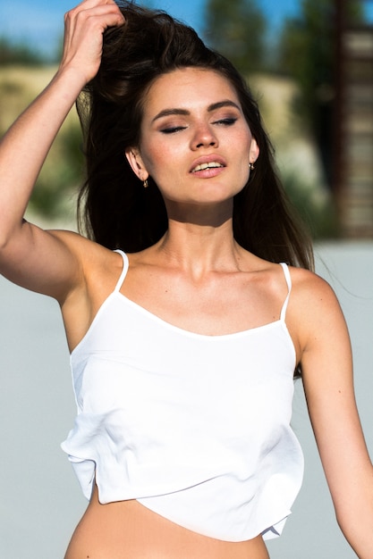 La donna scuote i lunghi capelli che si presentano sulla spiaggia