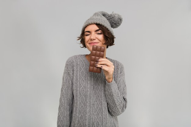 La donna si è vestita in maglione e cappello caldo che tiene il cioccolato.