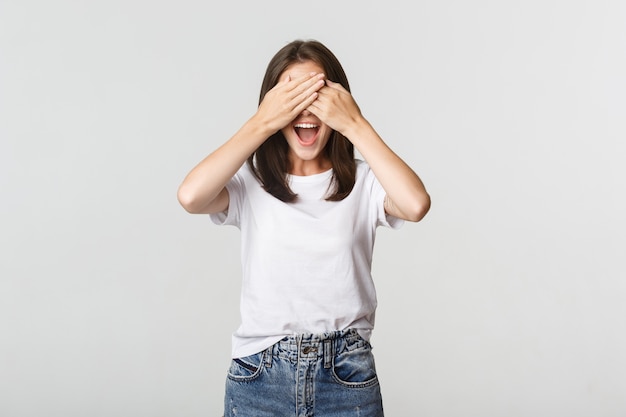 La donna sorridente allegra chiude gli occhi e aspetta la sorpresa.