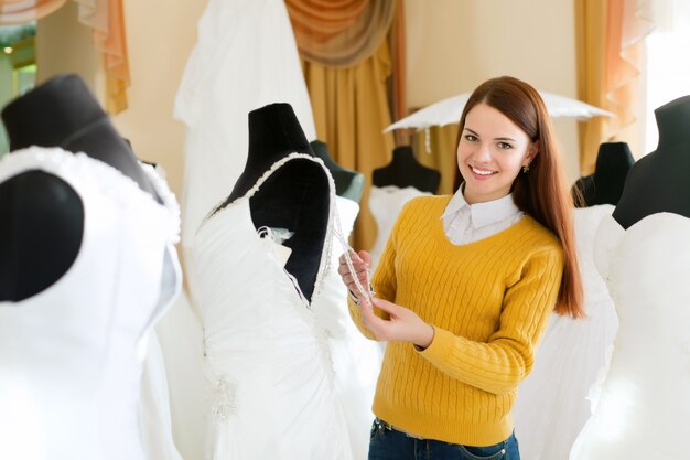 La donna sorridente sceglie l&#39;abito nuziale