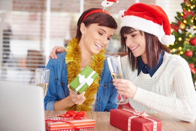 La donna sta mostrando il suo regalo di Natale ad un amico