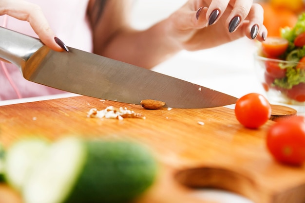 La donna taglia le mandorle sulla tavola di legno