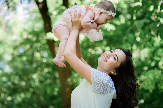 La donna tiene la sua piccola figlia in piedi in una foresta verde