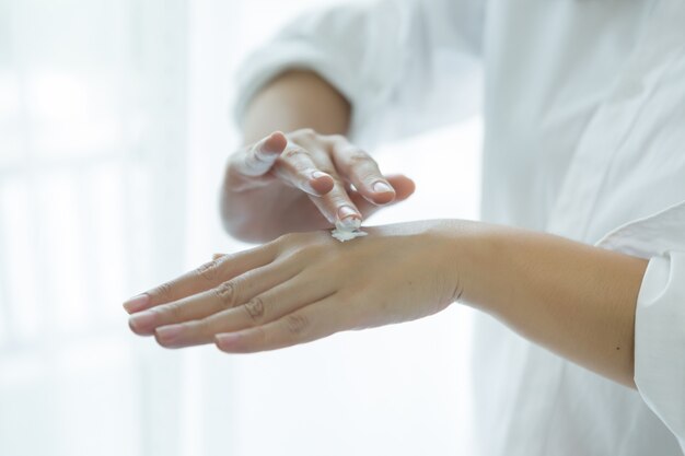 la donna tiene un vaso con una crema cosmetica nelle sue mani