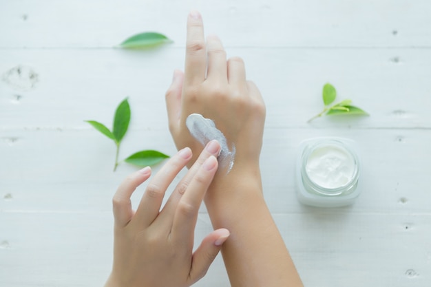 la donna tiene un vaso con una crema cosmetica nelle sue mani