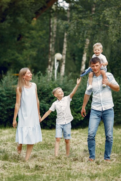 La famiglia cammina in un campo e gioca con l'aereo giocattolo