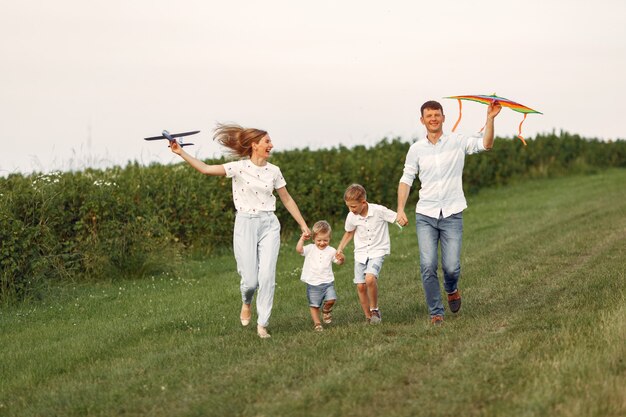 La famiglia cammina in un campo e gioca con l'aereo giocattolo