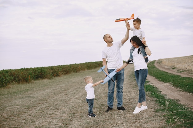 La famiglia cammina in un campo e gioca con l'aereo giocattolo