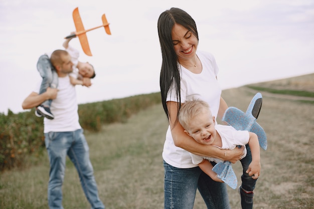 La famiglia cammina in un campo e gioca con l'aereo giocattolo