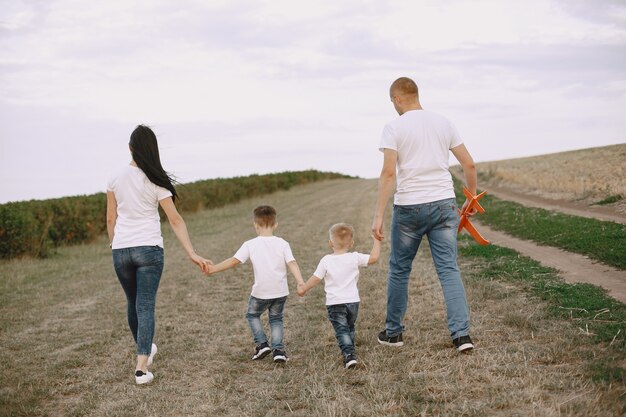 La famiglia cammina in un campo e gioca con l'aereo giocattolo