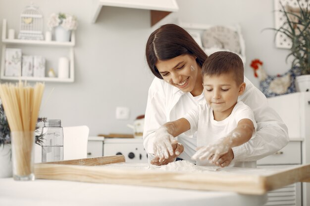 La famiglia che si siede in una cucina e cucina l'impasto per i biscotti