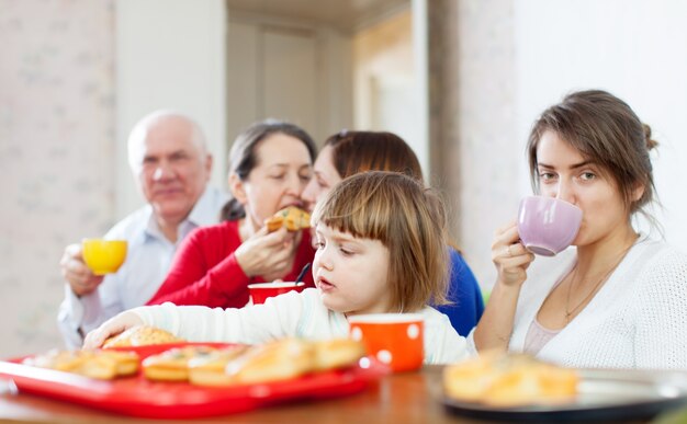 La famiglia comunica intorno alla tabella del tè