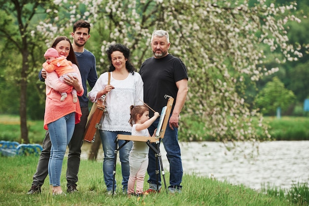 La famiglia si diverte nel parco. Giovane pittore che insegna a disegnare