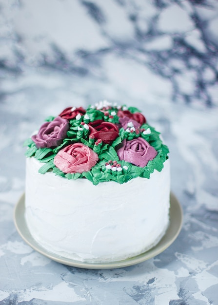 La fetta di torta della ragazza lattea ha decorato le foglie verdi ed i fiori del giglio, la torta decorata come mazzo del fiore, decorazione del dolce della molla