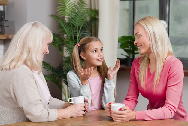 La generazione femminile felice parla l'un l'altro nella cucina