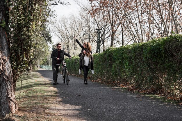 La gente che cammina con la bicicletta nel parco