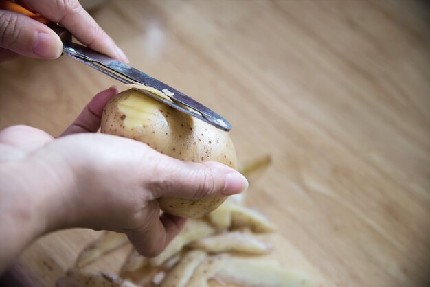 La gente che cucina patata fresca che prepara alimento nella cucina