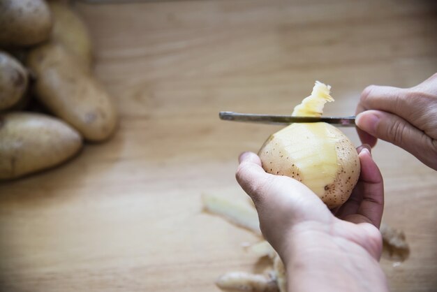 La gente che cucina patata fresca che prepara alimento nella cucina