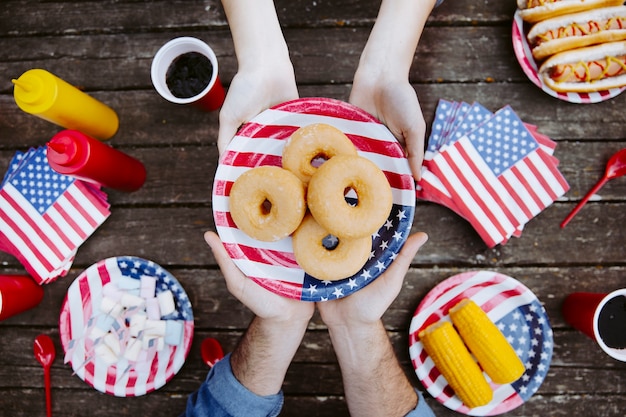 La gente che tiene piatto con bandiera americana