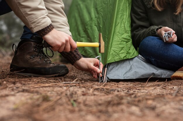 La gente del primo piano che mette sulla tenda verde