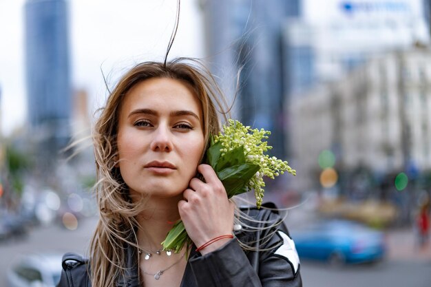 La giovane bella donna cammina per la città in Europa, foto di strada, donna in posa nel centro della città