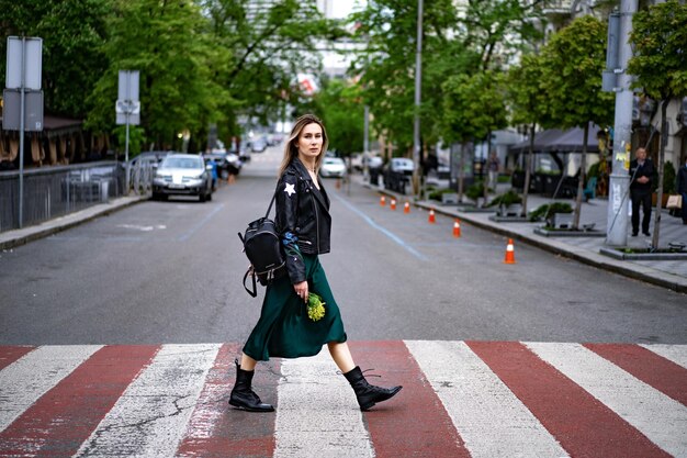 La giovane bella donna cammina per la città in Europa, foto di strada, donna in posa nel centro della città