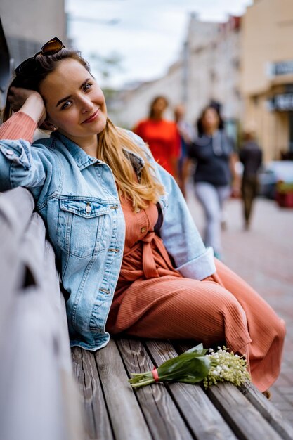 La giovane bella donna cammina per la città in Europa, foto di strada, donna in posa nel centro della città