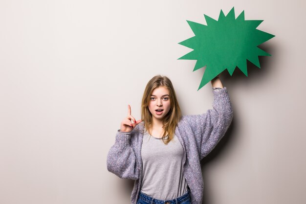 La giovane bella ragazza che tiene una bolla verde ha idea, isolata